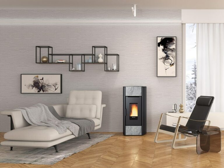 Un salon moderne avec une chaise longue, une cheminée noire EXTRAFRAME et une chaise noire avec une table d'appoint en verre. Le mur est orné d'œuvres d'art abstraites et d'étagères noires avec des objets de décoration. Une grande fenêtre laisse entrer la lumière naturelle, mettant en valeur le parquet en bois.