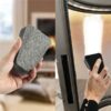 Une main tenant un objet rectangulaire gris ressemblant à une pierre ponce avec un arrière-plan flou à gauche. À droite, une main utilisant l'Éponge pour vitres de cheminées ou poêle - nettoyage à sec pour nettoyer une surface vitrée d'une porte de cheminée, éliminant ainsi efficacement la saleté et les résidus.