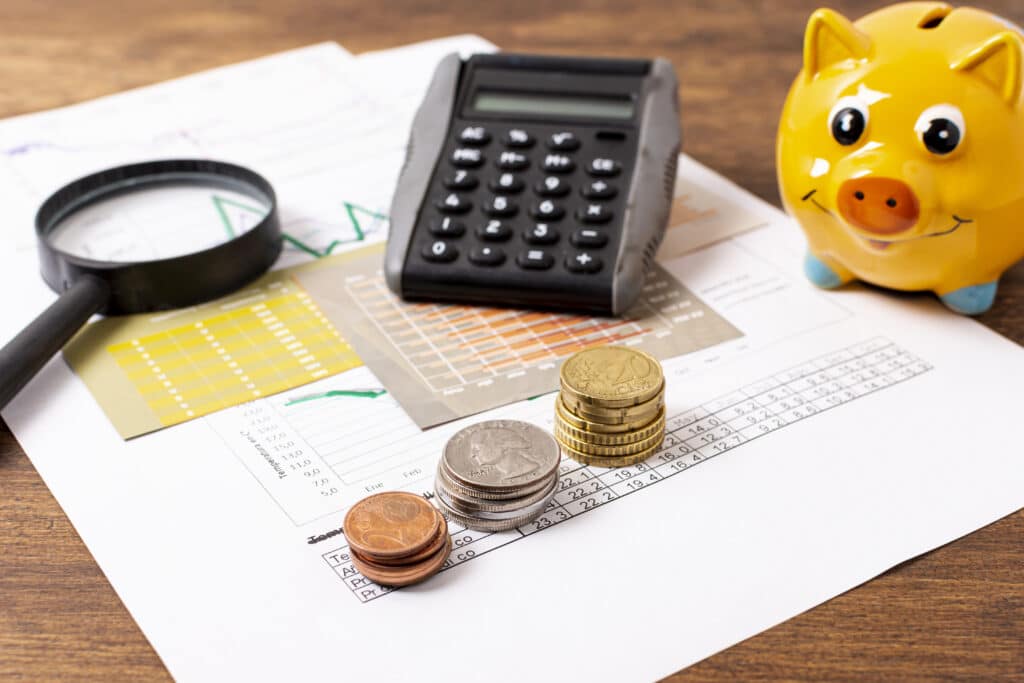 tirelire cochon jaune avec calculatrice, loupe et pièces de monnaie